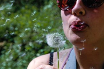 close-up-woman-blowing-dandelion